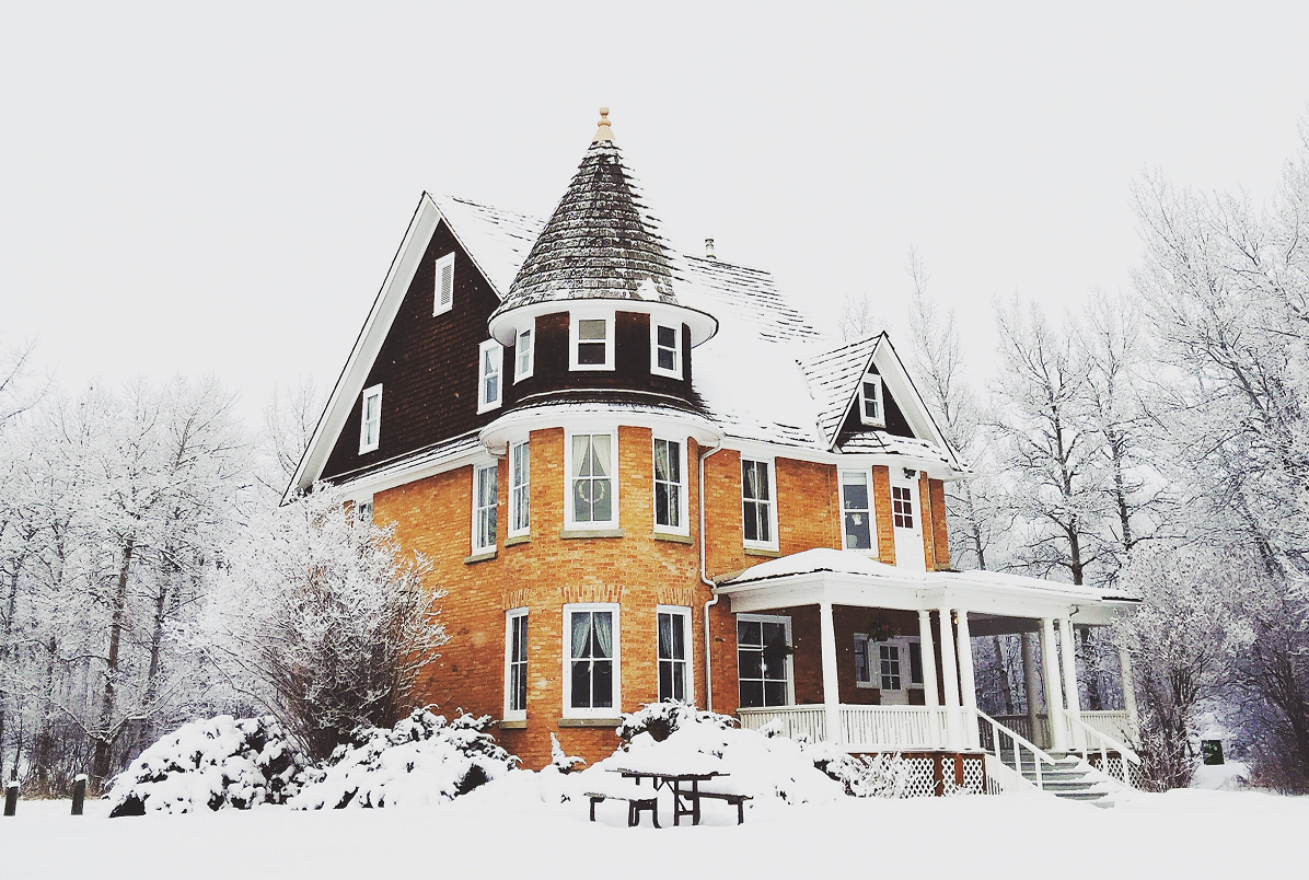 Elegáns, tornyos ház télen hóval fedve